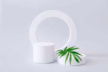 Geometrik şekiller, gri arkaplanda ürün gösterimi için podyumları şekillendirir. Ürün tanıtımını minimal biçimde temsil et.