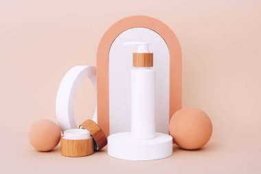 Geometrik podyumlarda kozmetik şişeler. Bej arka planda doğal güzellik ürünleri için sunum şablonu