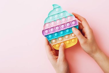 Moda oyuncağı anti-stres, pembe arka planda patlat, rahat oyuncak, üst manzara