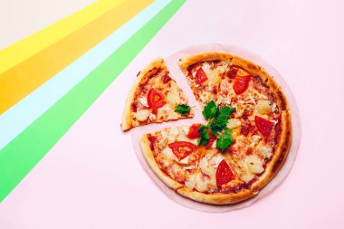 Renkli arka planda dilimlenmiş pizza. Üst görünüm
