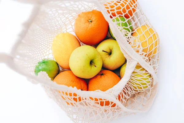 Сетка торговый мешок со свежими фруктами на светлом фоне. Отходы, концепция без пластика. — стоковое фото