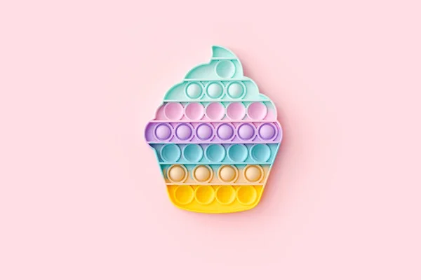 Popit toy in the form of a cupcake on a pink background, top view — Stock Photo, Image