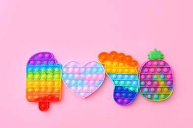 Renkli İtiş Patlat Köpük Duyusal Fidget Oyuncakları Pembe arka planda, üst görünümde