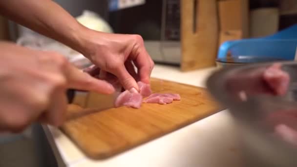 Cutting raw meat. The cook cutting raw meat on a wooden board with a knife. Closeup — Stock Video