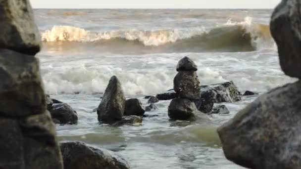 晴れた日にビーチでバランスの取れた石のピラミッド 背景に穏やかな海と波ではありません 海のビーチで禅の石 静けさ バランスの概念 — ストック動画