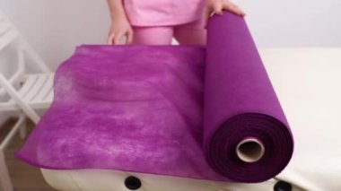 Kirpik ustası iş yerini hazırlar ve kanepeyi tek kullanımlık çarşafla kaplar.