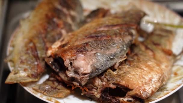 Eet gebakken kruisvis ligt op een bord, camera cirkelvormige beweging — Stockvideo