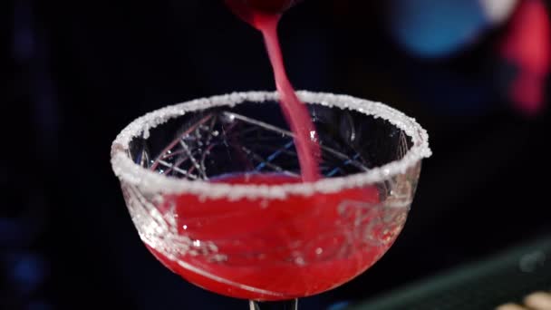 Klasický barman nalévá likér z vysoké sklenice na koktejlové sklo v interiérovém nóbl baru s měkkým interiérovým osvětlením. Zavřít — Stock video