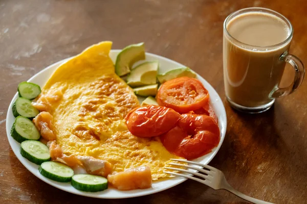Omlet, domates, salatalık, avokado salatası ve kahve ile kahvaltı.