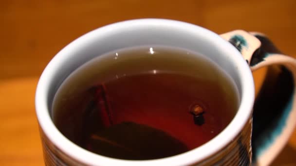 閉じるまで熱いお茶をカップ蒸し 天然木のテーブルの上で煙と熱いセラミックカップ背景 — ストック動画