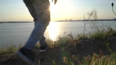 Adamın ayağı tepenin kenarına geldi, durdu ve nehrin batışını izledi..