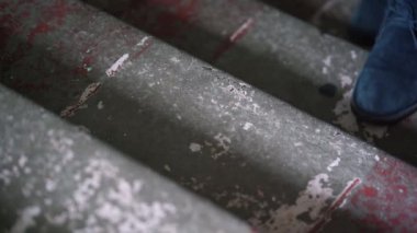 Zarif ayakkabılı adamın bacakları eski merdivenlerden yukarı çıkıyor.