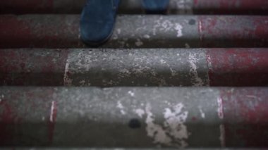 Zarif ayakkabılı adamın bacakları eski merdivenlerden yukarı çıkıyor.