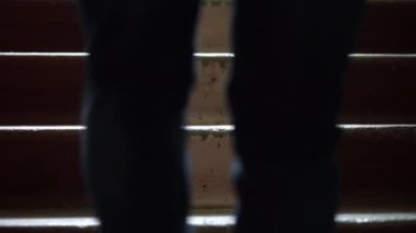 Zarif ayakkabılı adamın bacakları eski merdivenlerden yukarı çıkıyor.