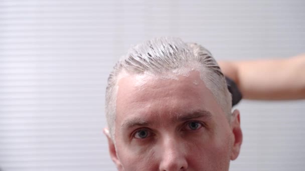 Adult man dyes his hair in a beauty salon — Stock Video