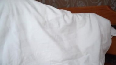 Bir adam battaniyenin altına saklanır. Korku kavramı.