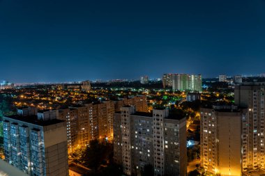 Gece manzarası, evlerin pencerelerinden gelen ışıklar, gökyüzündeki yıldızlar, uyuma alanı.