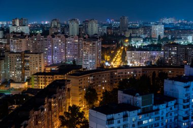Gece manzarası, evlerin pencerelerinden gelen ışıklar, gökyüzündeki yıldızlar, uyuma alanı.