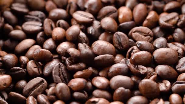 Kaffebönor faller långsamt på en hög med kaffebönor — Stockvideo