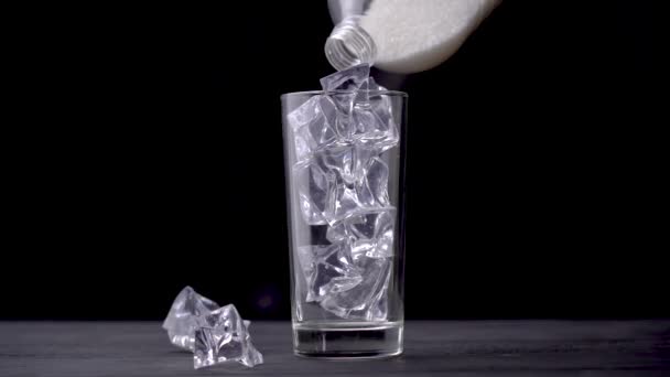 Açúcar derramado de garrafa em vidro com cubos de gelo fundo preto. Conceito — Vídeo de Stock