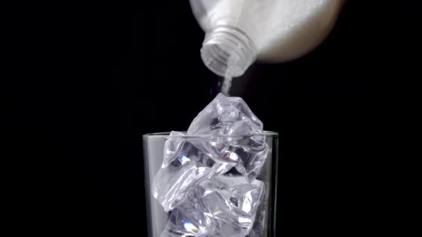 Sugar poured from bottle into glass with cubes ice black background. Concept — Stock Video