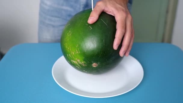 Mogen röd vattenmelon delad på mitten med kniv — Stockvideo