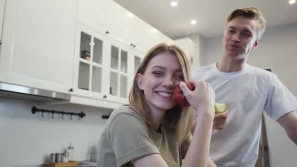 Ein Paar in der Küche. Grüne Äpfel essen. — Stockvideo