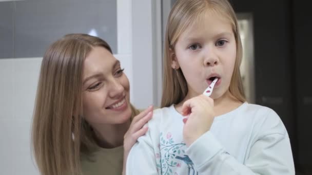 Madre e figlia. Lavaggio mattutino dei denti. Bagno. — Video Stock