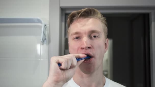 Ten chlap u zrcadla. Čistit zuby. Portrét. — Stock video