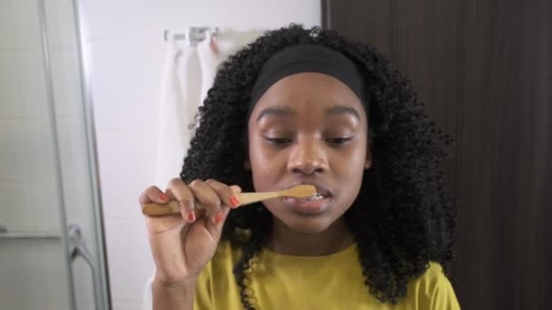 Black girl brushing his teeth. Hotel. — Stock Video