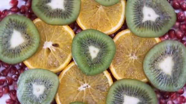 Orangen- und Kiwi-Scheiben. Granathintergrund. — Stockvideo