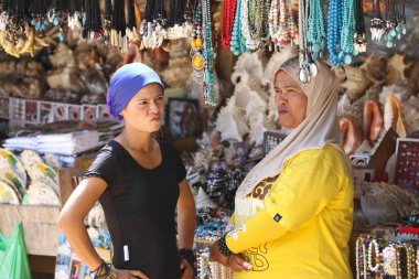 Markette hediyelik eşya satarken birbirleriyle konuşan iki Taylandlı kadın. Phi Phi, Tayland, 12 Mart 2012