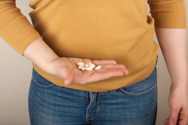 Elinde haplar olan bir kadın