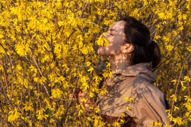 Çiçek kokan bir kadın çiçekli çalılıklarda