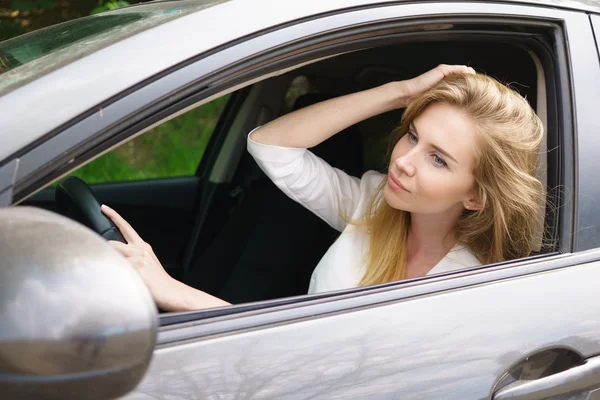 Mujer sonriente sentada en el coche —  Fotos de Stock