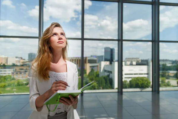 Jovem bela mulher segurando caderno verde . — Fotografia de Stock