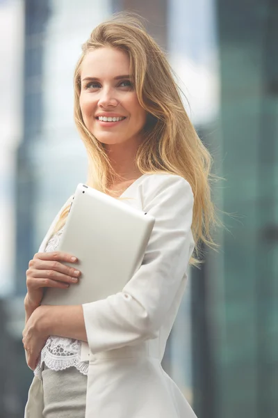 Beautiful woman using electronic tab in the street