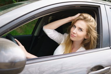 Smiling woman sitting in car clipart