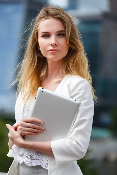 Beautiful woman with electronic tab in the street