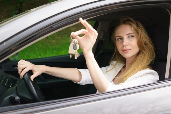 Mujer joven mostrando la llave del coche —  Fotos de Stock