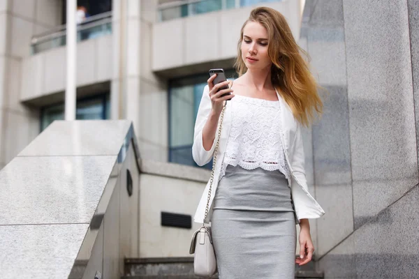 Joven mujer de negocios hablando por teléfono celular mientras camina al aire libre — Foto de Stock