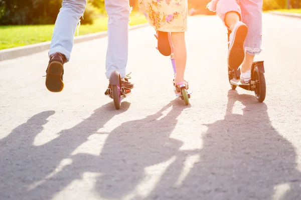 Genitori con scooter da equitazione per bambini in estate — Foto Stock