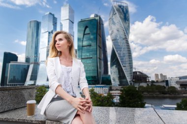 Office buidings karşı oturan genç kadın.