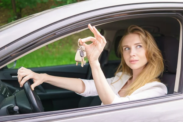 Молодая женщина показывает ключ от машины — стоковое фото