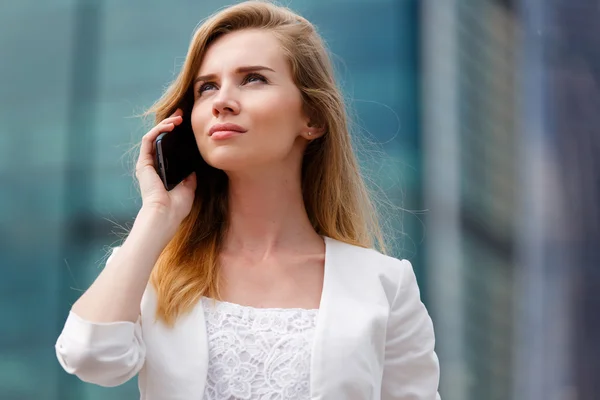 Młoda bizneswoman rozmawia przez telefon komórkowy podczas spaceru na świeżym powietrzu — Zdjęcie stockowe