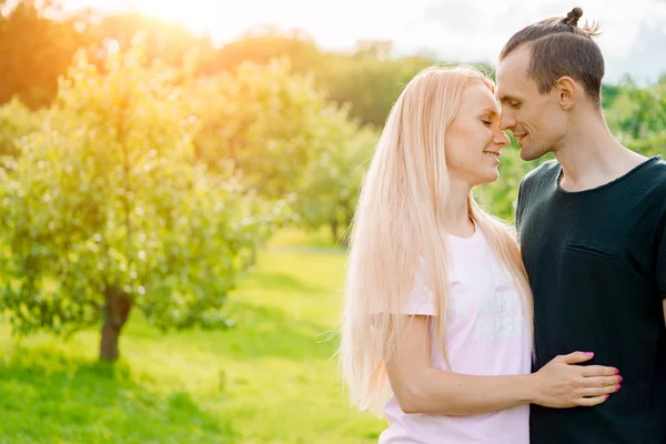 Casal de pé no parque e abraçando — Fotografia de Stock