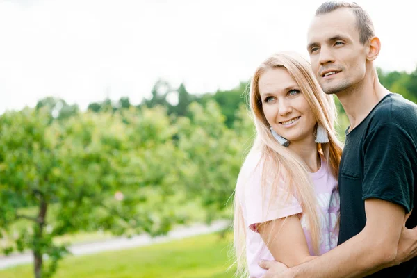 Paar staande in park en knuffelen — Stockfoto