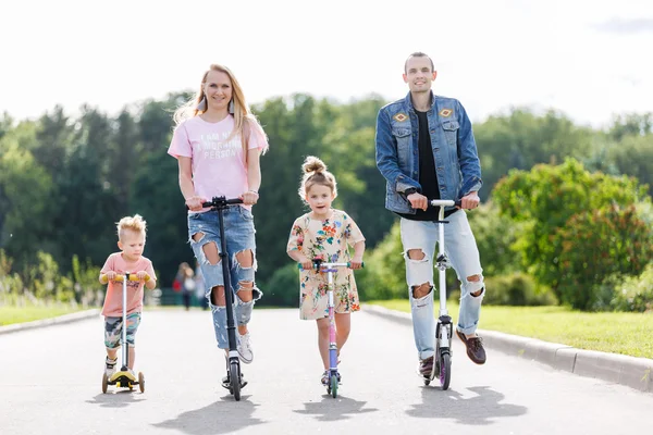 Família com scooters no parque — Fotografia de Stock