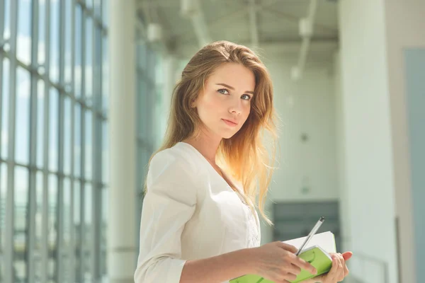 Молодая красивая женщина держит зеленый блокнот . — стоковое фото