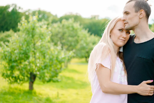 Paar staande in park en knuffelen — Stockfoto